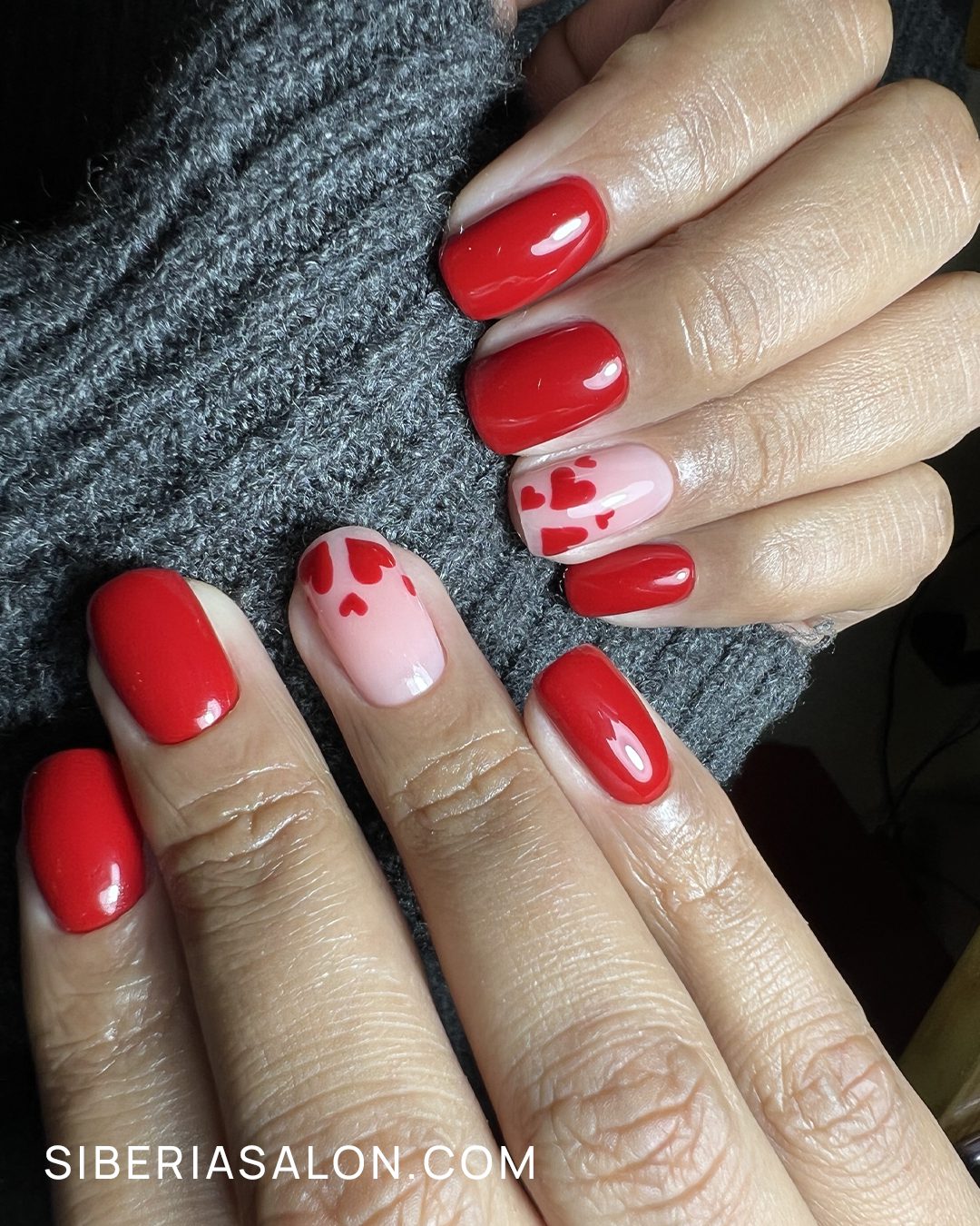 Uñas rojas o de color burdeos con diseños de corazones